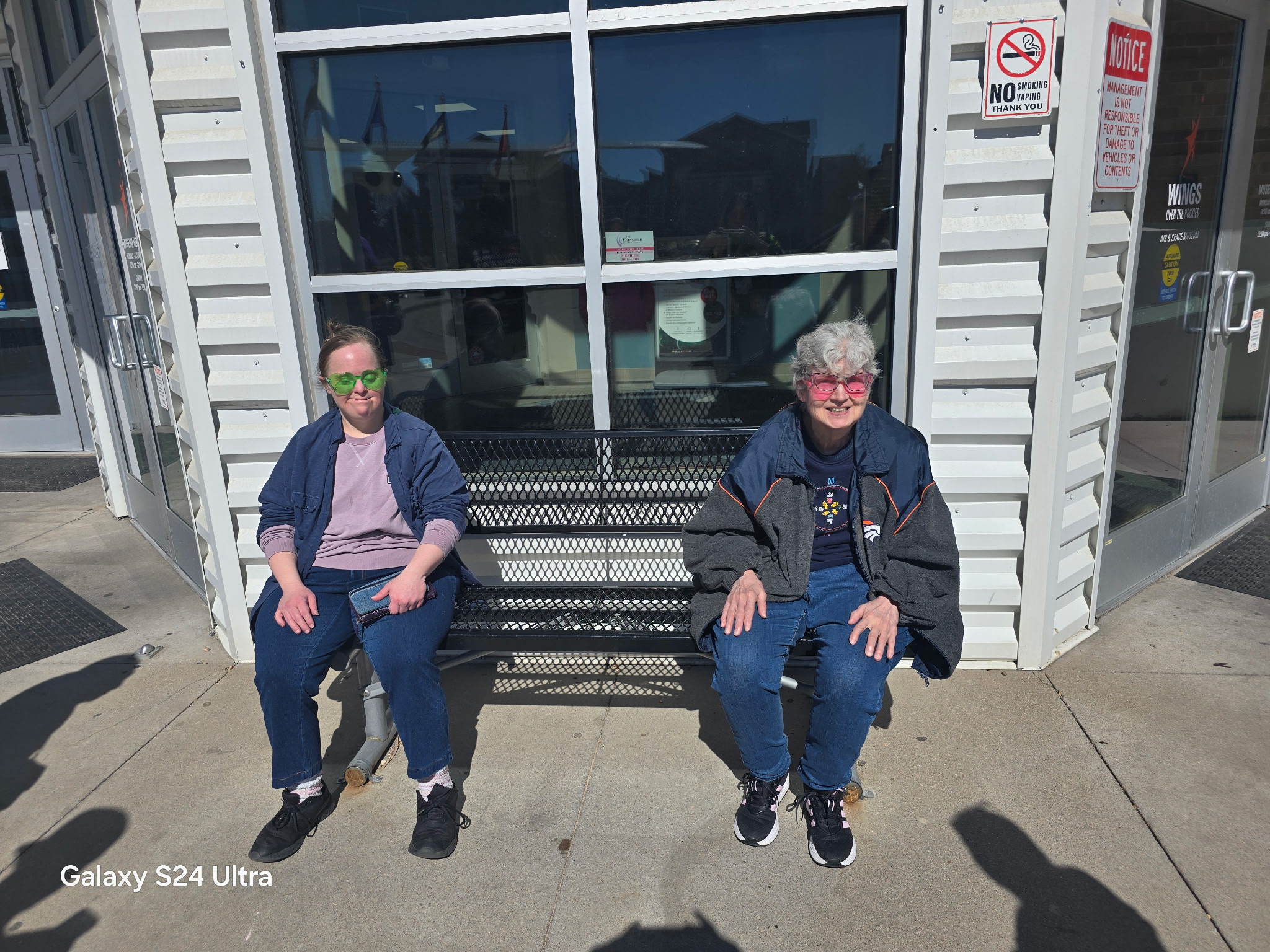 Two Brighter Horizon clients relaxing on a bench outside the Air and Space Museum on a sunny day
